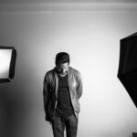 grayscale photography of standing man in studio